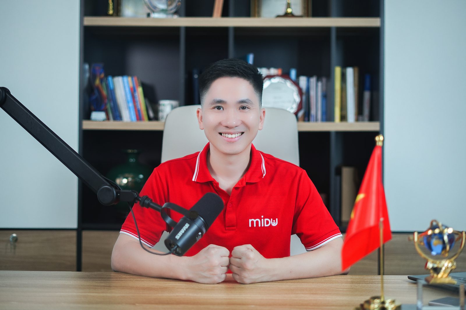 Nguyễn Xuân Hợp ngồi trước micro podcast